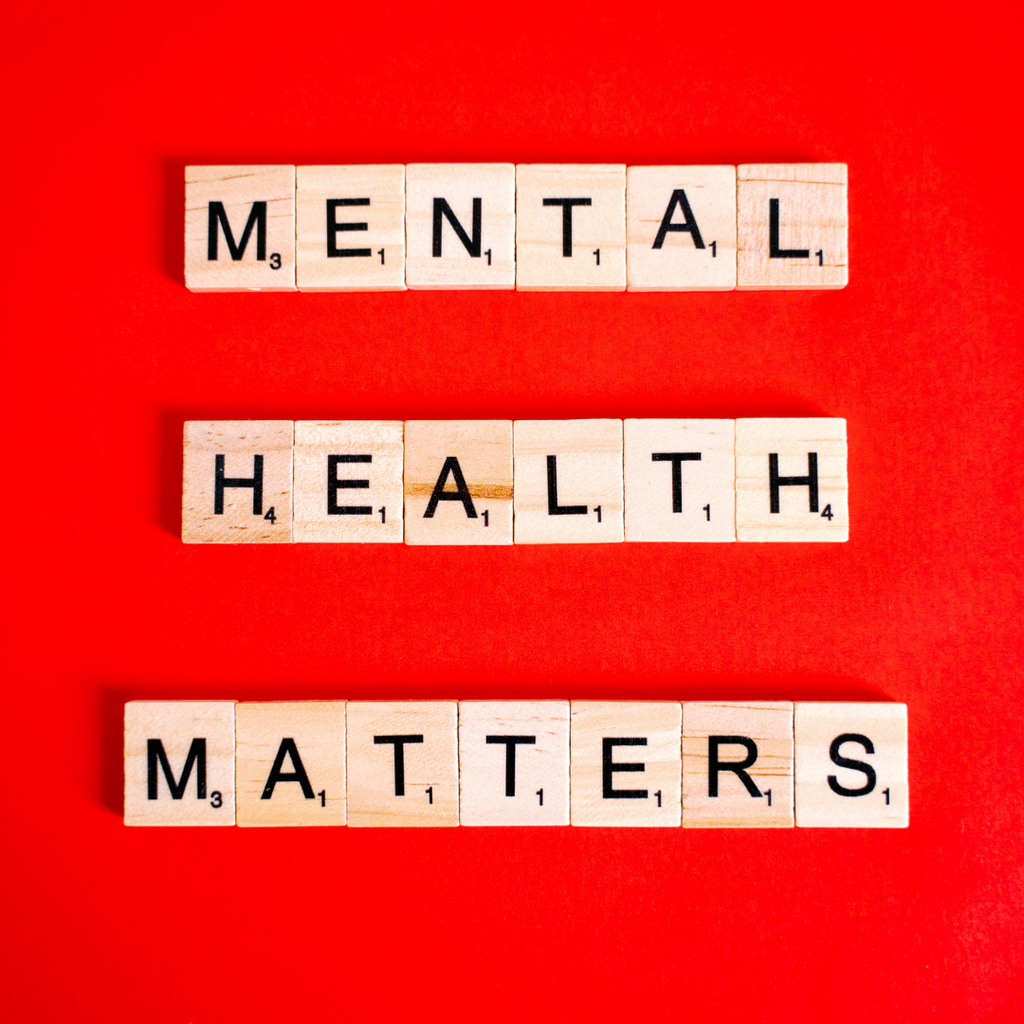 Scrabble tiles spelling out mental health matters on a red background