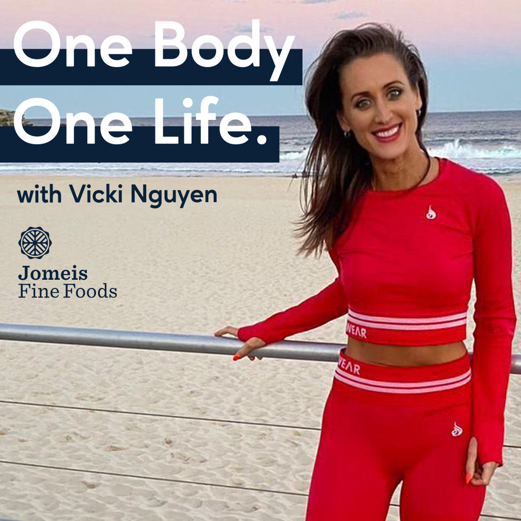 A photo of Jomeis Fine Foods founder, Vicki Nguyen. She is wearing a red, matching gym outfit. She is standing on a walkway at the beach. Beside her are the words "One Body One Life - with Vicki Nguyen." Below the writing is the Jomeis Fine Foods logo