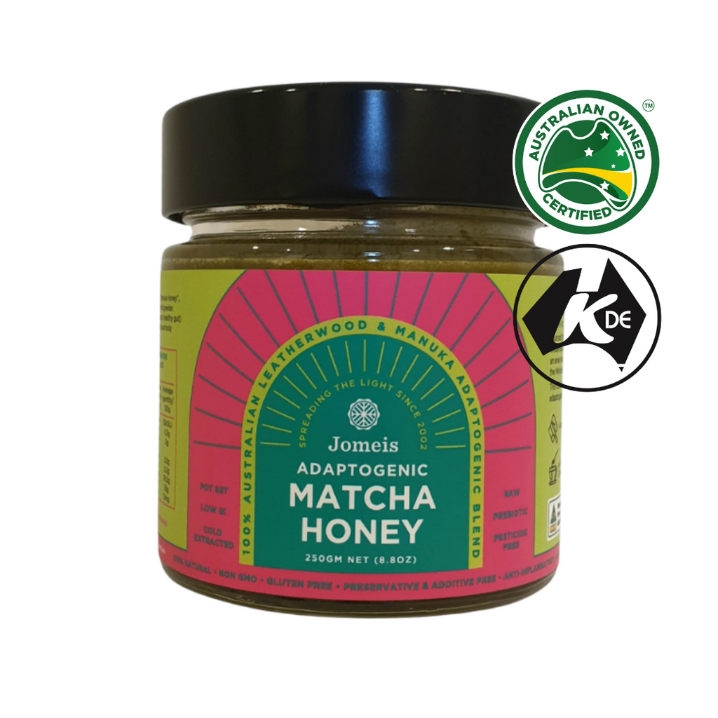 An adaptogenic matcha honey on a white backgroun. The honey pot's label is pink and green. 