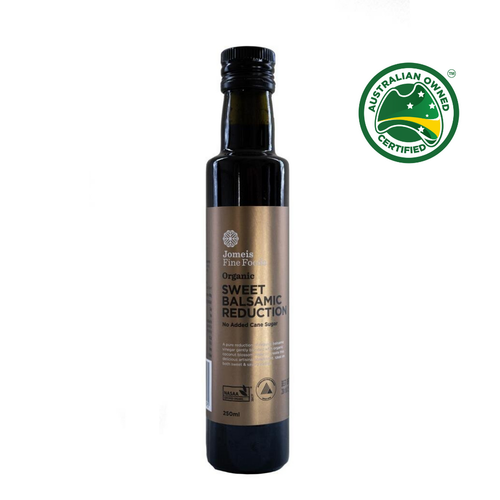 A bottle of a 250 ml Jomeis Fine Foods Sweet Balsamic Reduction. It has a gold label. It is sitting on a white background